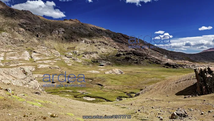 : Vast, mountainous landscape under a clear blue sky with white clouds : Vast, mountainous landscape under a clear blue sky with white clouds