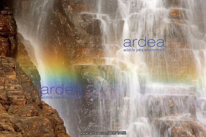 : waterfall and rainbow - water cascading down a : waterfall and rainbow - water cascading down a