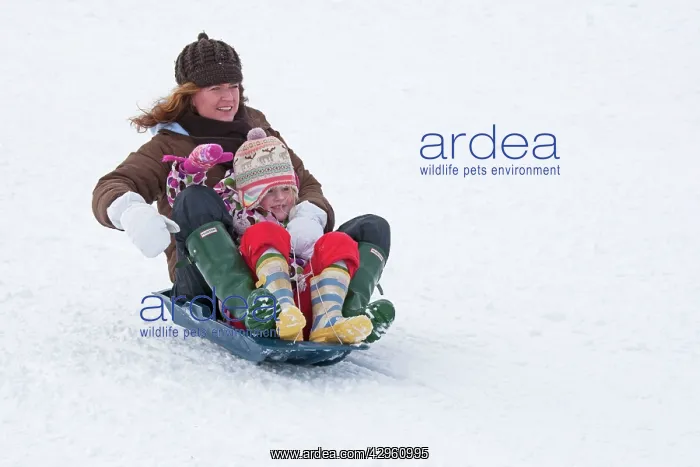: Woman and child sledging in deep snow : Woman and child sledging in deep snow
