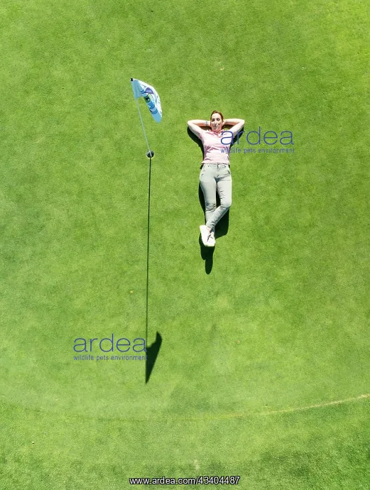 : Woman lying on the green at the La Noria Golf Resort : Woman lying on the green at the La Noria Golf Resort