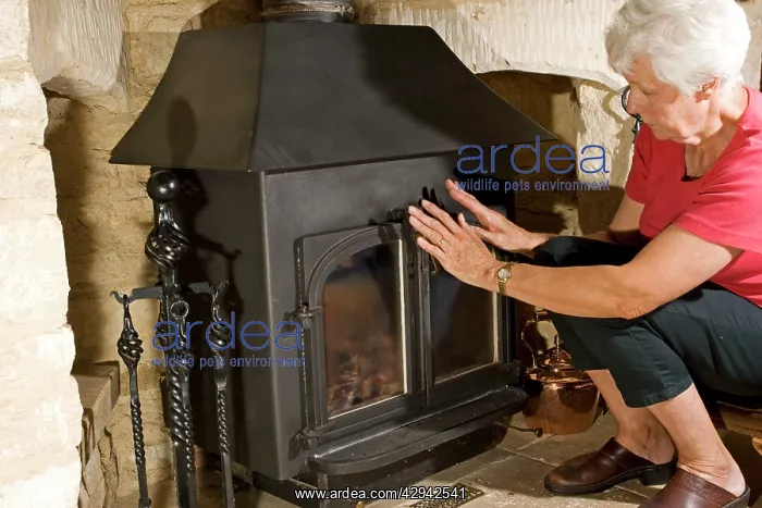 : Woman - warming hands on woodstove : Woman - warming hands on woodstove