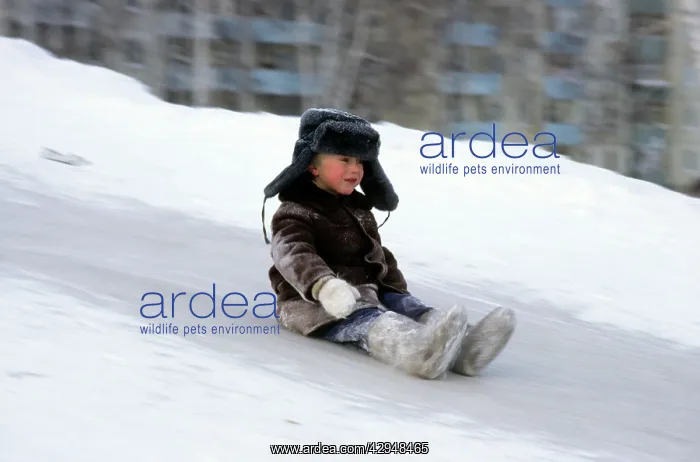 : Young boy does downhill-ice-sliding just on his : Young boy does downhill-ice-sliding just on his
