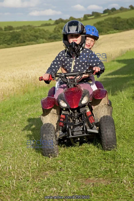 : Young girls riding mall quad bike - in farm field : Young girls riding mall quad bike - in farm field