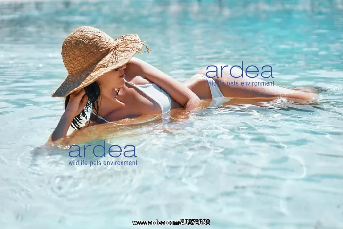 : Young woman in straw hat and white bikini relax : Young woman in straw hat and white bikini relax