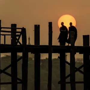 Burmese Buddhist Monks crossing U Bein Bridge at dawn