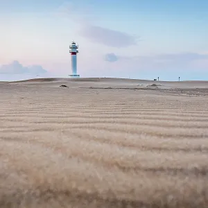 Lighthouse at sunrise with dunes