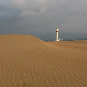 Lighthouse at sunrise with the dunes