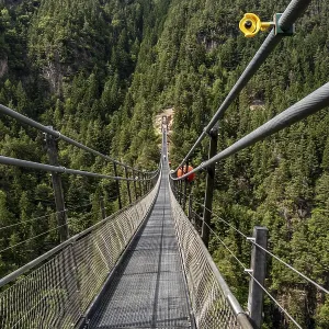 Suspension bridge with safety camera over wooded gorge in the Sarntal Valley Suspension bridge with safety camera over wooded gorge in the Sarntal Valley