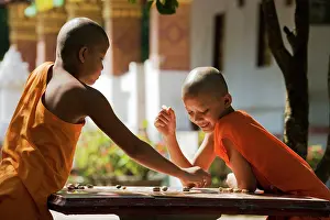 Monks: 2 young Buddhist novices playing a board game in