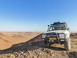 Wheel: 4x4 vehicle on a small hill in desert landscape