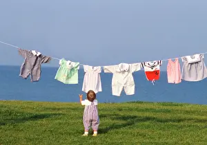 Frederic Rolland: 80201376 Child - young child hanging clothes to