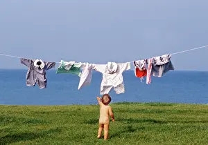 Frederic Rolland: 80201377 Child - naked young child hanging clothes