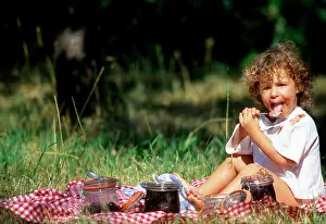 Frederic Rolland: 80202468 Child - licking spoon at picnic Frederic