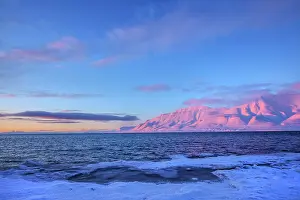 Sunrays: Adventfjorden sunset - last sunrays casting pink light on mo