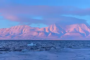 Sunrays: Adventfjorden sunset - last sunrays casting pink light on mo