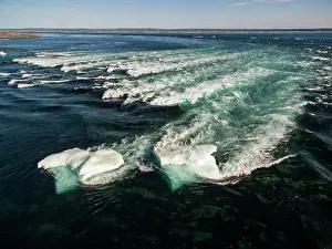 Rapids: Aerial view of iceberg grounded in shallow rapids