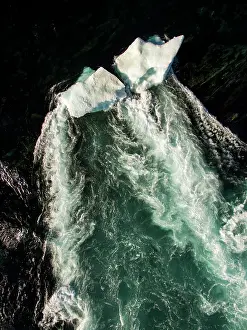 Rapids: Aerial view of iceberg grounded in shallow rapids