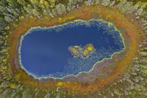 Swedish: Aerial view over small pond with blue water in bog