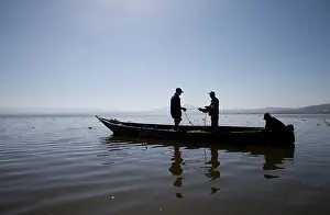 Canoes: African Fishermen - silhouettes - with nets in dugout canoe