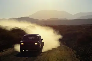 Imprint: All-terrain vehicle with dust cloud on track through