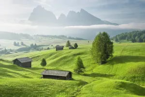 Cabin: Alpine huts on green pastures in front of mountains