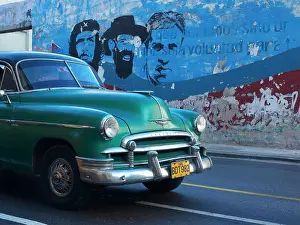 Avenues: American vintage cars as a Cuban taxi driving along