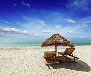Local: Two beach lounge chairs under tent on beach. Sih
