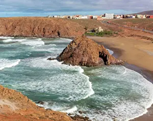 Spray: Beach rocky outrcop coastline in bay, Plage Sidi