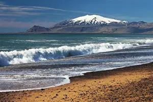 Vesturland: Beach with surf, behind snow covered volcano and