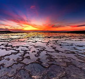 Pebble: A beautiful sunset over the ocean with rocky beach
