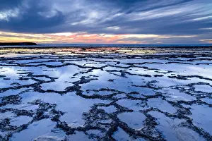 Pebble: A beautiful sunset over the ocean with rocky beach