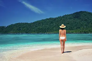 Paradise: Beautiful young woman in white bikini and straw