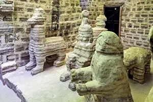 Resort: Beige stone sculptures of animals in a rustic room with patterned brick walls