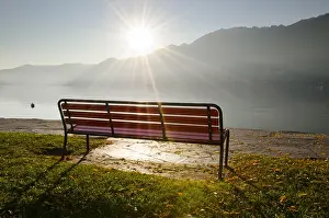 Bench: Bench in backlit with sunbeam on the foggy lake