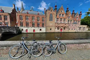 Canals: Bicycles leaning against a canal wall with medievel