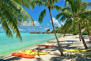 Huts: Boats on the beach under palm trees, South Pacific