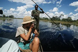 Chris Harvey: BOTSWANA - tourist in a makoro canoe taking photo