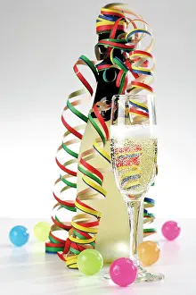 Celebrations: Bottle and glass with champagne, streamers and coloured