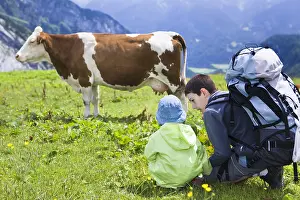 Ager: Boy and girl looking at a cow Abondance Alpes France