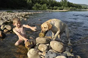 Baths: Boy playing with his dog in Eyrieux River Ardeche France