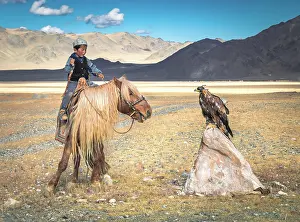 Local: A boy trains his young eagle for hunting. After