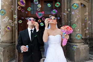 Joyful: Bride and groom, bridal couple blowing bubbles