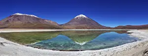 Quiet: Broad mountain backdrop with two snow-covered peaks reflected in a calm lake