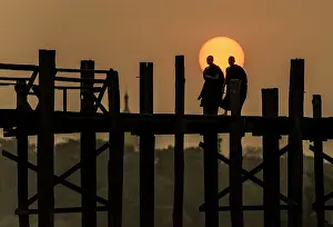 Burma: Burmese Buddhist Monks crossing U Bein Bridge at dawn