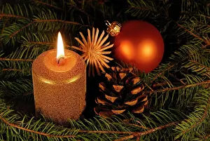Burning: A burning candle with Christmas decoration
