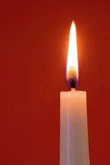Lifestyle: Burning candle on red background