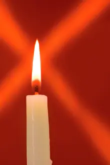 Lifestyle: Burning candle with star burst on red background