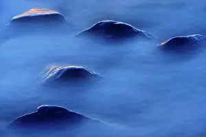 Foam: Canada, Manitoba. Sunset on rocks protruding