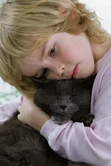 Cuddled: Cat - being cuddled by young child