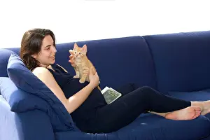 Pregnant: Cat - girl holding ginger kitten on sofaLady is pregnant